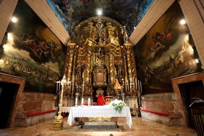 Altar principal dorado y pinturas murales en el interior de la basílica