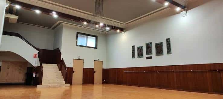 Sala de baile o eventos con suelo de madera y escalera