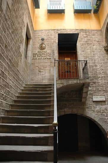 Escalera de acceso al edificio con balcón y puerta principal