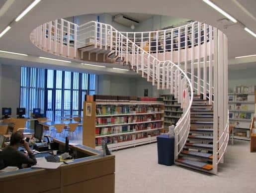 Interior de la biblioteca con escalera espiral y estanterías