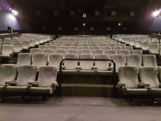 Interior de la sala de cine con butacas blancas dispuestas en gradas