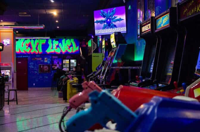Interior del bar con máquinas arcade y neón
