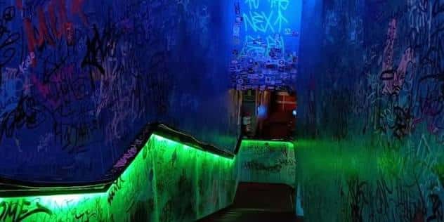 Pasillo decorado con grafitis y luces LED verdes