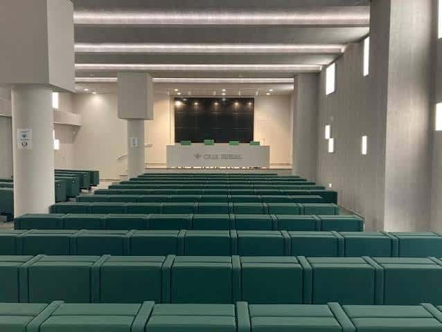 Vista interior del auditorio de la Fundación Caja Rural del Sur con butacas verdes y escenario