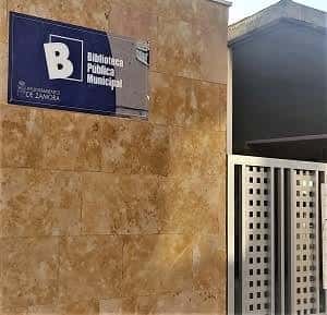Señalética oficial de la Biblioteca Pública Municipal en fachada de piedra