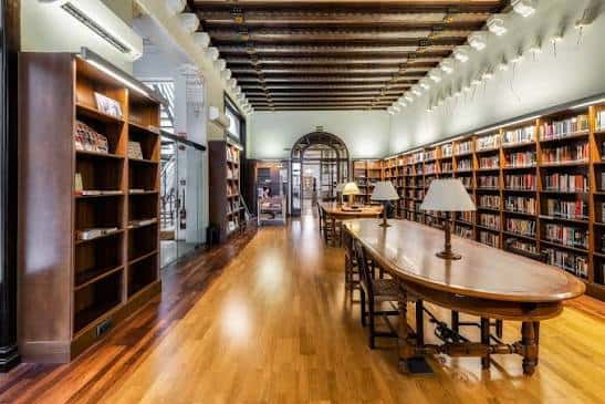 Vista panorámica del interior de la Sala Ramon Amigó con estanterías de madera y mesas de lectura