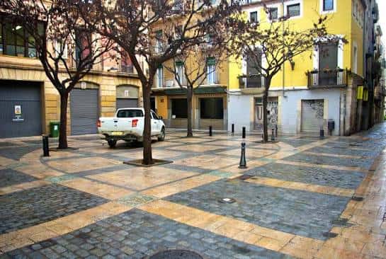 Vista general de la Plaça de la Farinera con árboles y pavimento geométrico