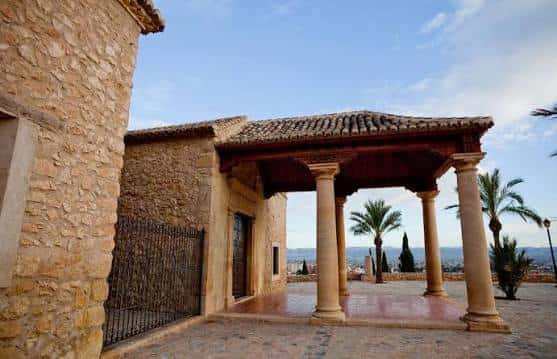Vista del pórtico con columnas y la muralla de Lorca al fondo