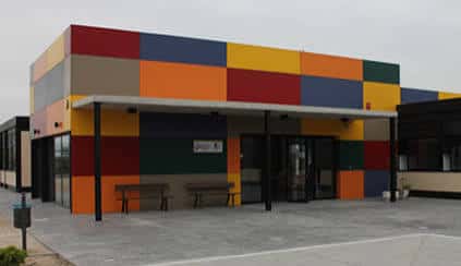 Fachada colorida del Centro Apandis en Lorca con paneles multicolores y entrada principal