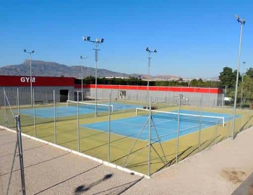 Pistas de pádel con superficie azul y vallas perimetrales