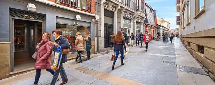 Calle comercial peatonal en Getxo con tiendas y transeúntes