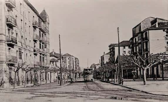 Vista histórica de una calle arbolada en Getxo con tranvía antiguo