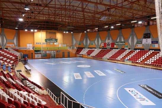 Vista general del interior del Pabellón Polideportivo René Marigil con gradas rojas y blancas y pista de baloncesto azul