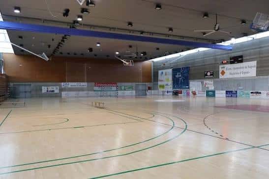 Pista de madera del pabellón con líneas verdes para deportes, sin espectadores ni publicidad prominente