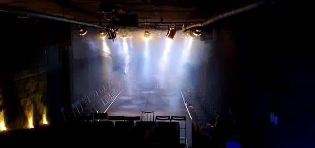 Vista panorámica del escenario principal con iluminación dramática y humo