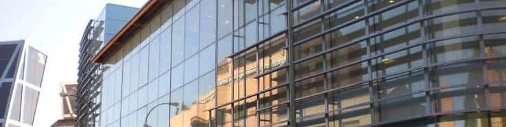 Vista lateral del edificio con detalles arquitectónicos y banderas institucionales