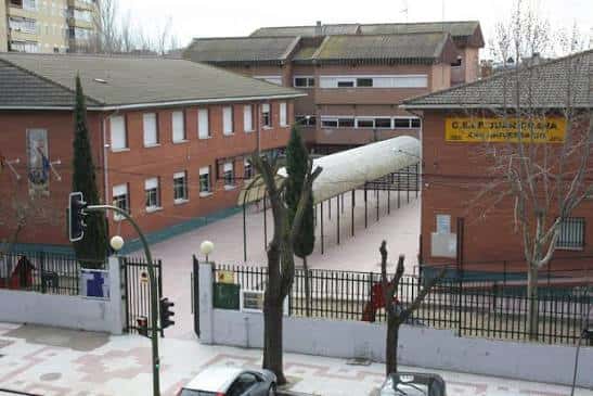Vista exterior del CEIP Juan Ocaña mostrando la fachada principal y el patio central con pasarela cubierta