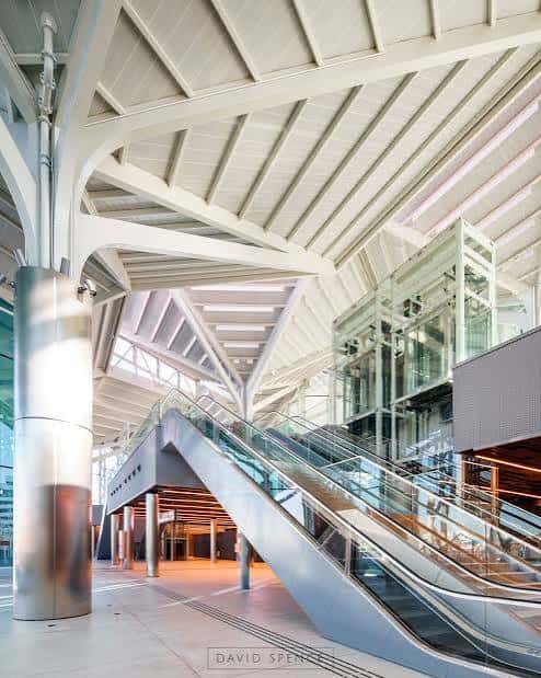 Detalle interior del intercambiador con escaleras mecánicas y elementos estructurales blancos