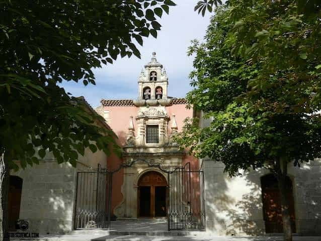Fachada del santuario enmarcada por árboles frondosos bajo cielo azul