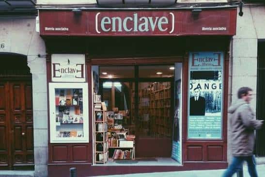 Fachada exterior de la librería Enclave en Madrid con letrero distintivo y escaparate