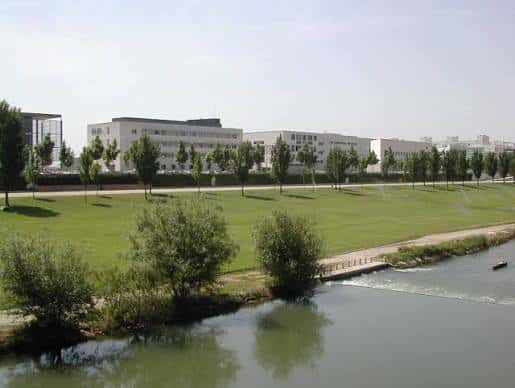 Edificios del campus vistos desde el río Segre con prado frente a ellos