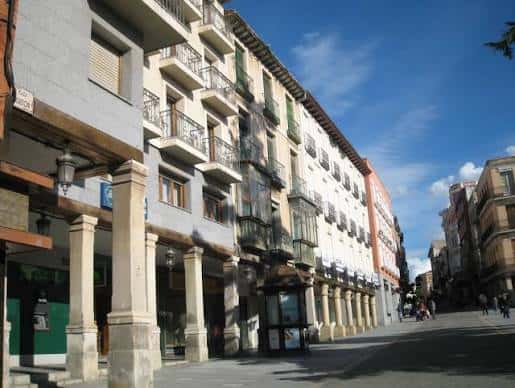 Fachada colonial con soportales y balcones tradicionales bajo un cielo azul despejado