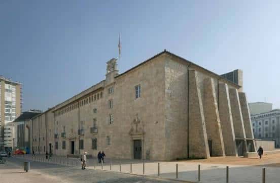 Fachada histórica de piedra adyacente al complejo moderno