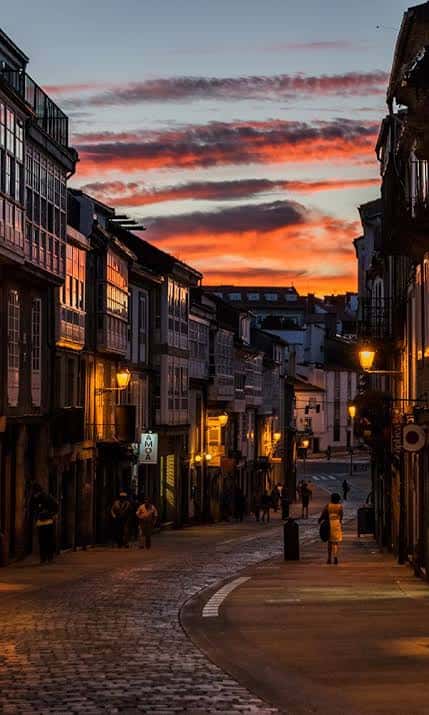 Atardecer en la Rúa de San Pedro con iluminación cálida y cielo dramático