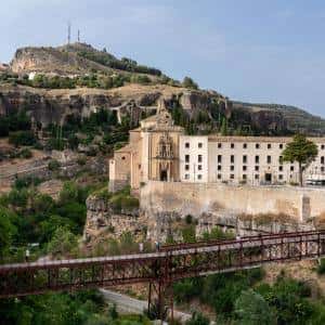Fachada histórica del Parador con el puente colgante al fondo