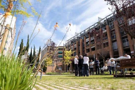 Vista general de la Plaça Onze de Setembre con áreas verdes y personas reunidas