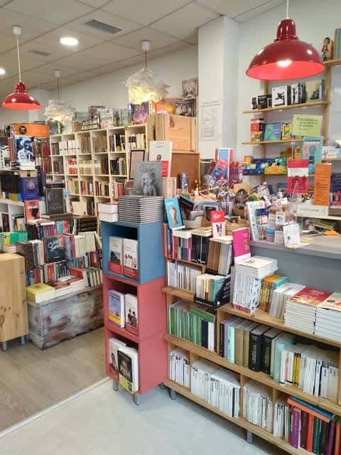 Vista del mostrador y sección de libros en Casa Tomada, con iluminación roja y organización visual