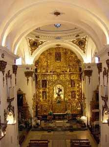 Interior del altar mayor dorado de la Iglesia de San Francisco con bóvedas iluminadas