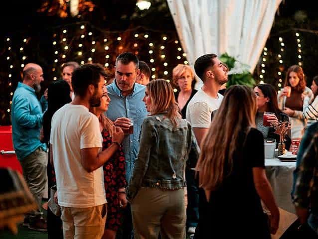 Reunión social con invitados en el patio iluminado