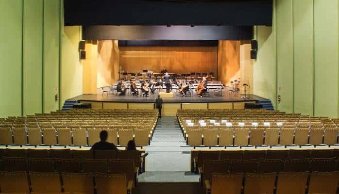 Interior del auditorio durante un concierto sinfónico con orquesta en escena