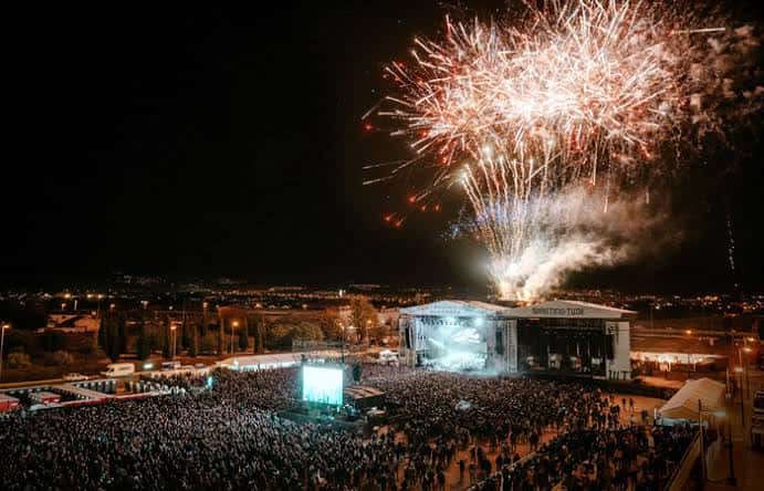 Vista panorámica nocturna del festival Granada Sound con fuegos artificiales sobre el escenario y multitud