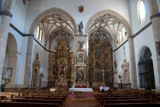 Interior de la Iglesia de San Andrés mostrando el altar mayor con retablo dorado y bóvedas góticas