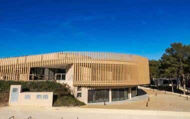 Fachada principal del edificio del parque con revestimiento de madera bajo cielo azul