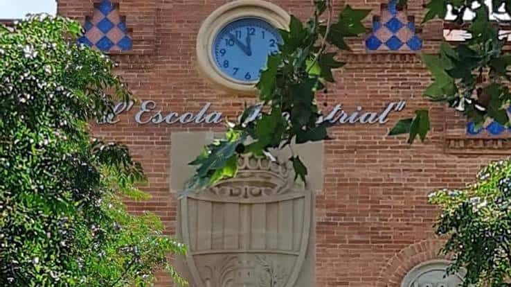 Detalle del escudo y el reloj en la fachada de ladrillo de la Escola Industrial