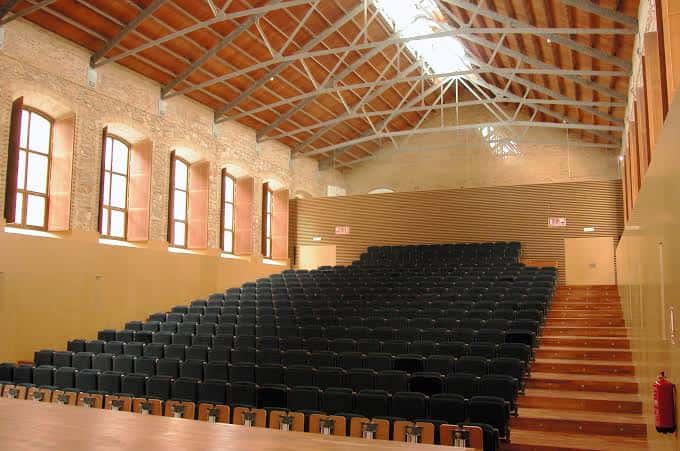 Vista general del pabellón deportivo con suelo de parquet y canchas marcadas