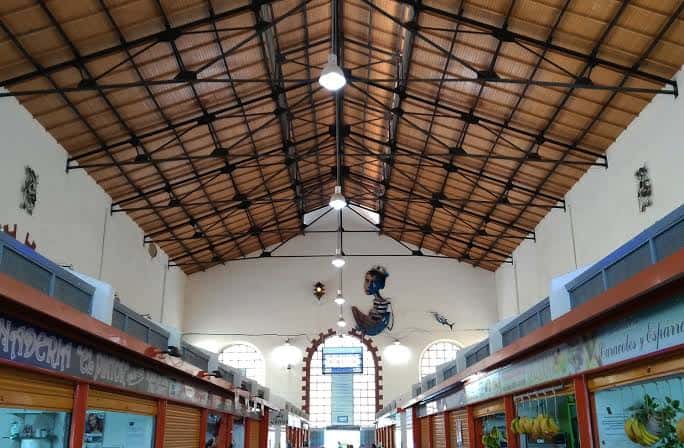 Interior del mercado mostrando la estructura metálica y techumbre de madera