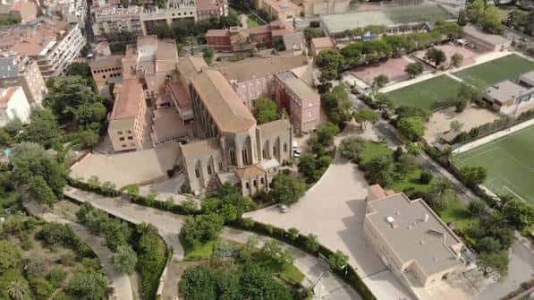 Vista aérea del campus escolar con campos deportivos y zonas verdes