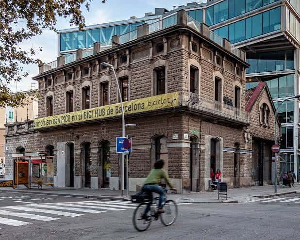 Fachada exterior del edificio industrial Can Picó con un ciclista en primer plano