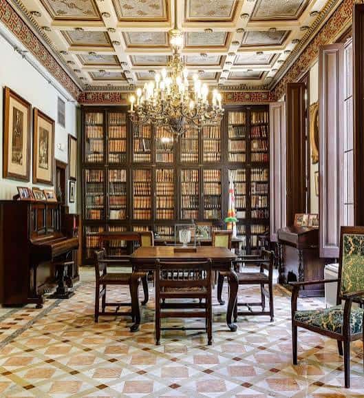 Sala de lectura principal con lámpara de araña y estanterías llenas de libros