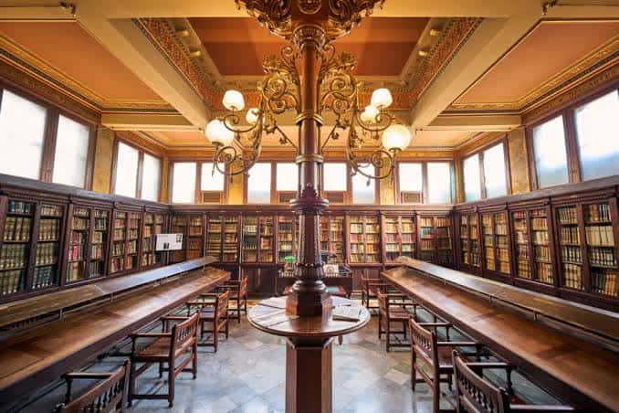 Vista panorámica del salón de lectura con columnas ornamentadas y mesas largas