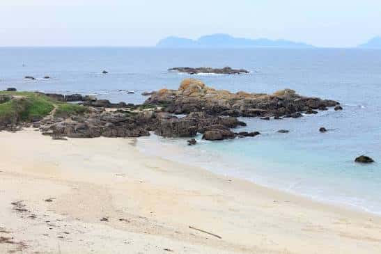 Vista panorámica de la playa con rocas y mar en calma