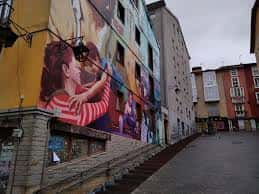 Vista de la calle Cantón de Anorbín con un mural colorido en la fachada