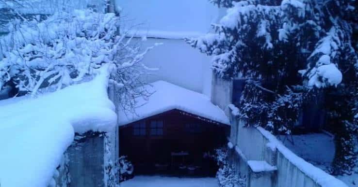 Escena invernal del Cantón de Anorbín con edificios cubiertos de nieve