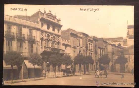 Vista histórica de la Plaza Pi i Margall con edificios antiguos y árboles