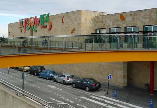 Vista exterior del Centro Comercial El Tormes con su fachada de piedra y el logo multicolor