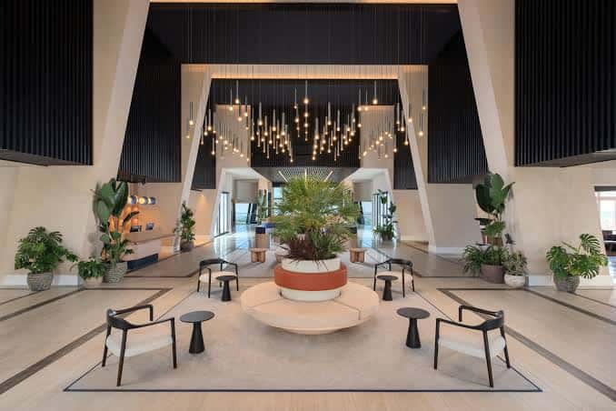 Lobby moderno con iluminación colgante y plantas decorativas